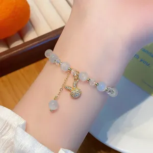 Vue détaillée d'un joli bracelet de perles avec un charmant pendentif lapin délicat.