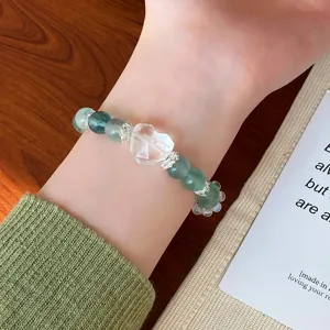 Detailed close-up view of elegant mint green fluorite crystal beaded bracelet with clear heart charm.