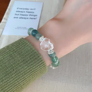 Detailed shot of fresh mint green fluorite crystal bead bracelet with cute heart charm.