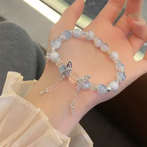 Delicate blue crystal glass bead bracelet featuring a charming silver butterfly pendant detail.