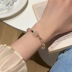 Close-up detail view of lovely pink crystal beaded bracelet with charming floral charm.