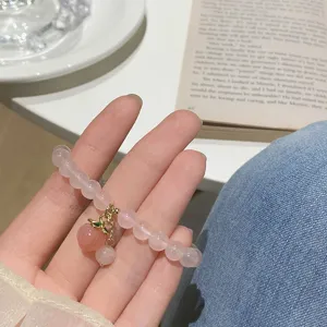 Delicate pink crystal beaded bracelet featuring a cute peach pendant, sweet style jewelry.