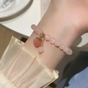 Close-up of cute pink crystal peach bracelet detail, sweet style wrist jewelry accessor.