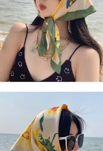 Detailed shot of a stylish floral silk square scarf worn as a chic headscarf and neck accessory.