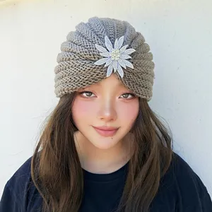 Detailed view of the rhinestone flower knit turban hat, cozy wool material, elegant winter fashion.