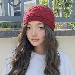 Detail view of a cozy wine red knitted winter headband, stylish cable knit ear warmer for women.