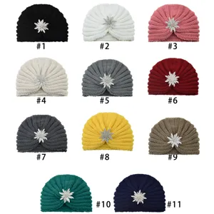 Close up details of various colors knitted turban hats with sparkling rhinestone flower brooch.