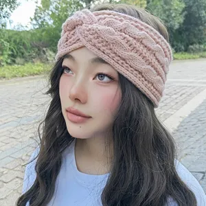 Close-up detail of the cozy pink knit headband worn by model outdoors, soft woolen texture.