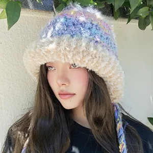 Nahaufnahme der farbigen flauschigen Strick-Bucket-Hat mit Plüschrand und niedlichen Zöpfen.