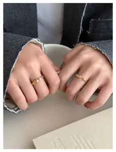 Nahaufnahme Detailansicht minimalistischer offener Wassertropfen Goldring und Perlenring an.