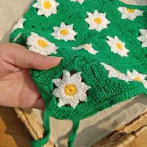Crochet daisy headband detail showing intricate green knit texture and handmade flower pattern