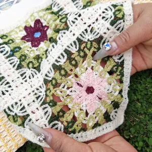Nahaufnahme des bunten Häkel-Hohlstrick-Haarband-Stoffs mit sehr feinen floralen Mustern.