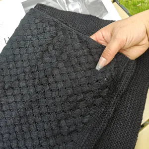 Primo piano dettaglio di tessuto in maglia nera, sciarpa calda morbida invernale.