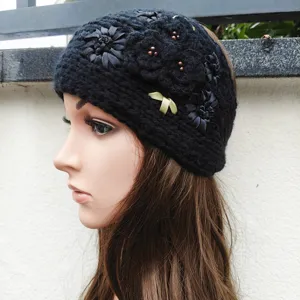 Fascia in maglia nera con fiori in nastro e perline, elegante accessorio per capelli invernali.