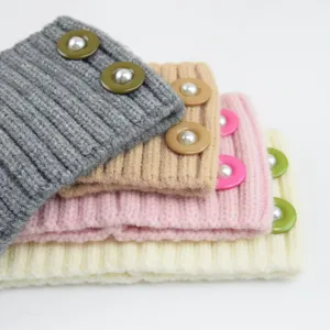 Detailed shot of ribbed knit headbands with pearl buttons in assorted cozy colors.
