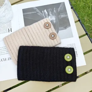 Detailed view of cozy knit ear warmer headbands with pearl button details in neutral tones.