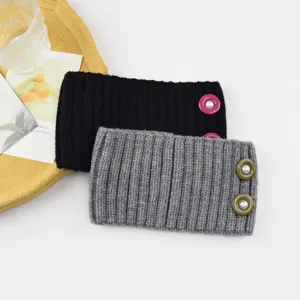 Detailed shot of knitted ribbed headbands with pearl buttons, stylish ear warmers for winter.