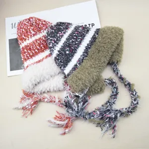 Detailed view of plush knitted earflap beanies with colorful braided tassels for winter.
