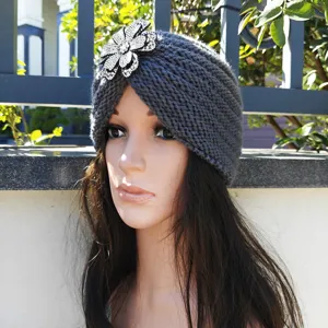 Grey knitted turban hat featuring a sparkling rhinestone flower, warm winter headwear.