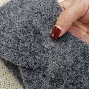 Close-up detail of dark grey fleece knitted winter headband, showing soft plush fabric texture.
