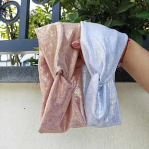 Nahaufnahme von glänzenden Metallic-Knoten-Haarbändern in Roségold und Silberfarben.