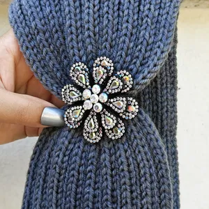 Knitted winter headband featuring a sparkly rhinestone flower brooch for warm and stylish daily wear.