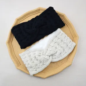 Detailed close-up of winter fleece-lined knit headband cross crochet design in black and beige.