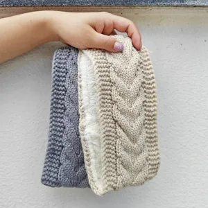 Details of warm cable knit fleece lined headband in grey and beige colors for winter use.