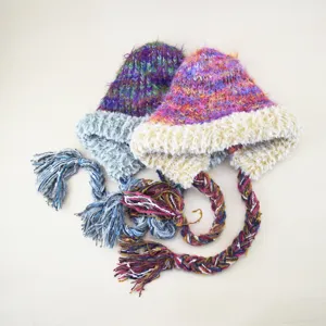 Nahaufnahme der bunten plüschigen geflochtenen Strickmütze mit flauschigen Ohrenklappen.