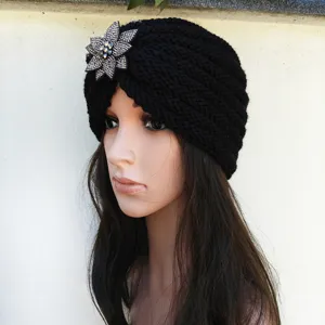 Black knitted turban hat with rhinestone flower for women, warm winter fashion headwear.