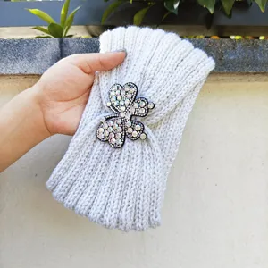 Graues Strick-Haarband mit glitzerndem Strass-Kleeblatt-Patch, warmes Winteraccessoire.