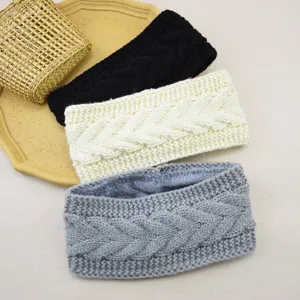 Close-up detail of cozy cable-knit fleece-lined winter headbands in three classic colors.
