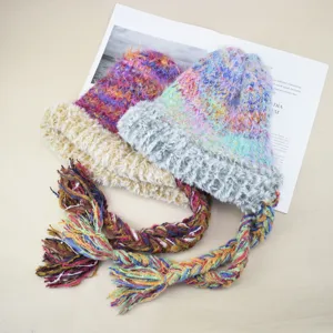 Bunte flauschige Strickmütze mit langen geflochtenen Quasten für gemütlichen Winter.
