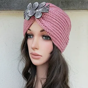 Pink knitted turban hat featuring sparkling rhinestone flower detail, warm winter head wrap for women.