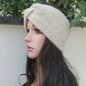 Detail view of the soft knitted wide headband, warm winter ear warmer with stylish cross design.