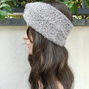Detail shot of fuzzy knit headband, soft plush winter ear warmer in stylish grey color.