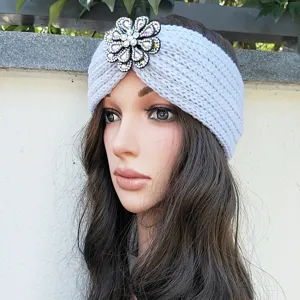 Light blue knit headband with sparkly crystal flower brooch, warm winter hair accessory.