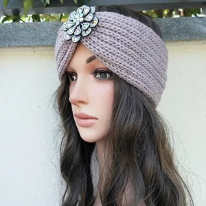 Detailed view of rhinestone flower knitted headband, warm winter hair accessory for women.