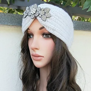 Detailed view of white knitted headband featuring sparkling rhinestone crystal floral embellishments.