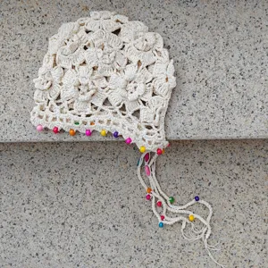 Handmade crochet knit hat with colorful beads, hollow floral pullover cap with tassel braid.