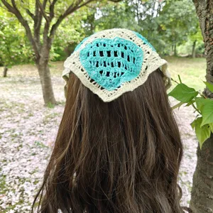 Crochet hair bandana detail, blue heart pattern knit headscarf, outdoor lifestyle view.