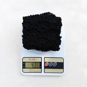 Vue détaillée du bonnet slouchy noir en crochet sur une balance, texture tricotée à la main.