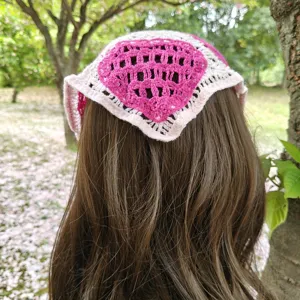 Close-up detail shot of the knitted pink heart pattern triangular headscarf back view.