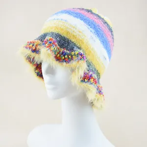 Dettaglio in primo piano del cappello bucket a righe colorate con bordo soffice per l'inverno.