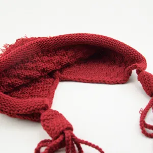 Berretto in maglia rossa con nappine dettaglio mostra chiaramente il motivo uncinetto.