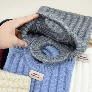 Detailansicht der stilvollen Strickhandtasche mit gemütlicher Zopfmusterstruktur und Riemen.