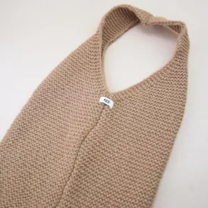 Detailaufnahme der beige-melierten Strick-Einkaufstasche mit feiner Textur und Stoffetikett.