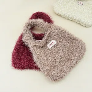 Primo piano dettaglio della borsa in maglia morbida peluche, borsa invernale accogliente.