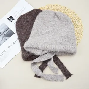 Detailed view of cozy solid color wool knitted beanie hats with cute ribbon ties for women.