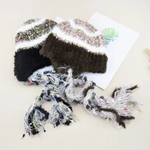 Detailed view of the winter knitted hat with long braided fringe and soft fuzzy texture.